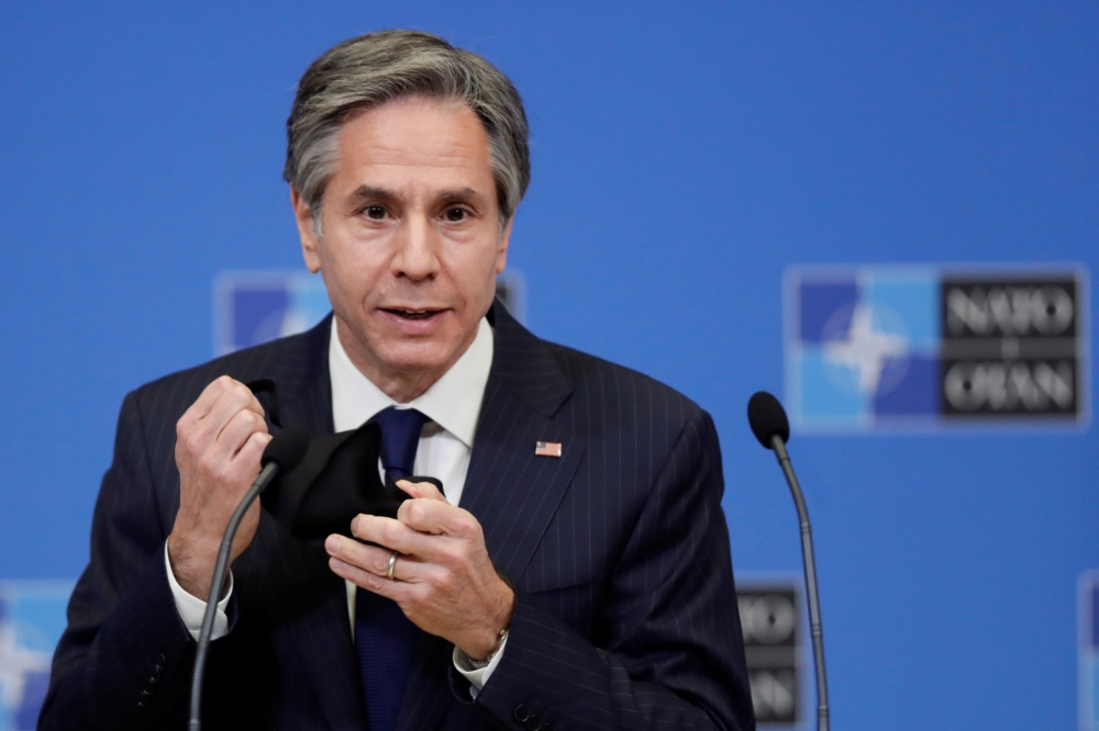 FILE PHOTO: U.S. Secretary of State Antony Blinken removes his mask as gives a press briefing at the end of a NATO Foreign Ministers' meeting at the Alliance's headquarters in Brussels, Belgium, March 24, 2021. Olivier Hoslet/Pool via Reuters