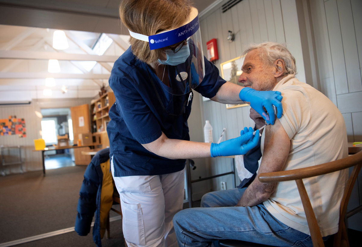 FILE PHOTO: A health worker vaccinates an elderly person with Pfizer's COVID-19 vaccine at a temporary vaccination clinic in a church in Sollentuna, north of Stockholm, Sweden March 2, 2021. Fredrik Sandberg/TT News Agency/via REUTERS