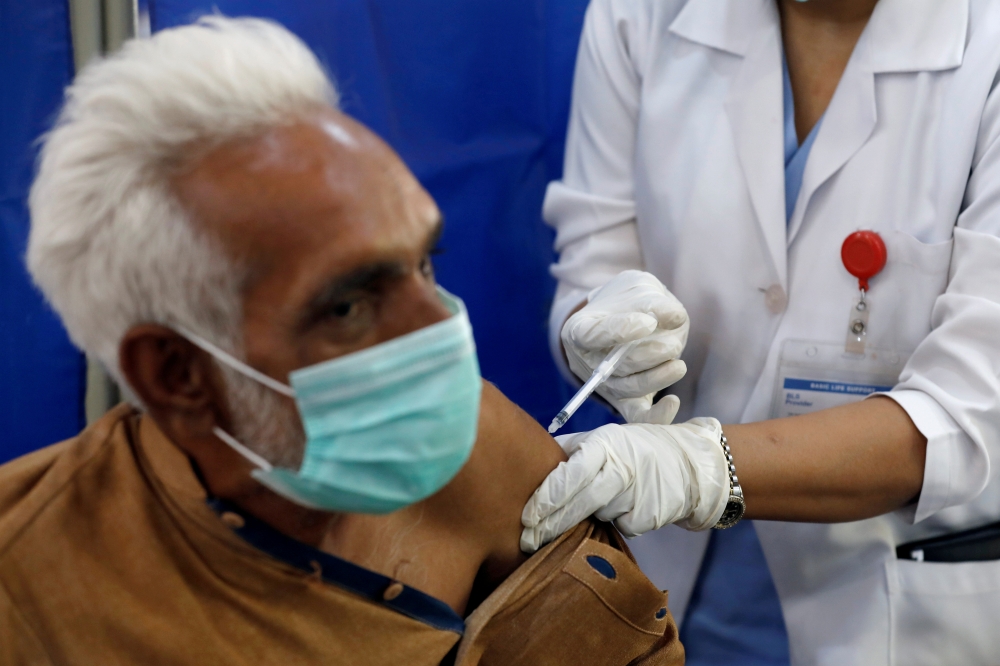 FILE PHOTO: An elderly resident receives the first dose of the coronavirus disease (COVID-19) vaccine, as the government started vaccination for the general public, starting with elderly people, at a vaccination center in Karachi, Pakistan March 10, 2021.