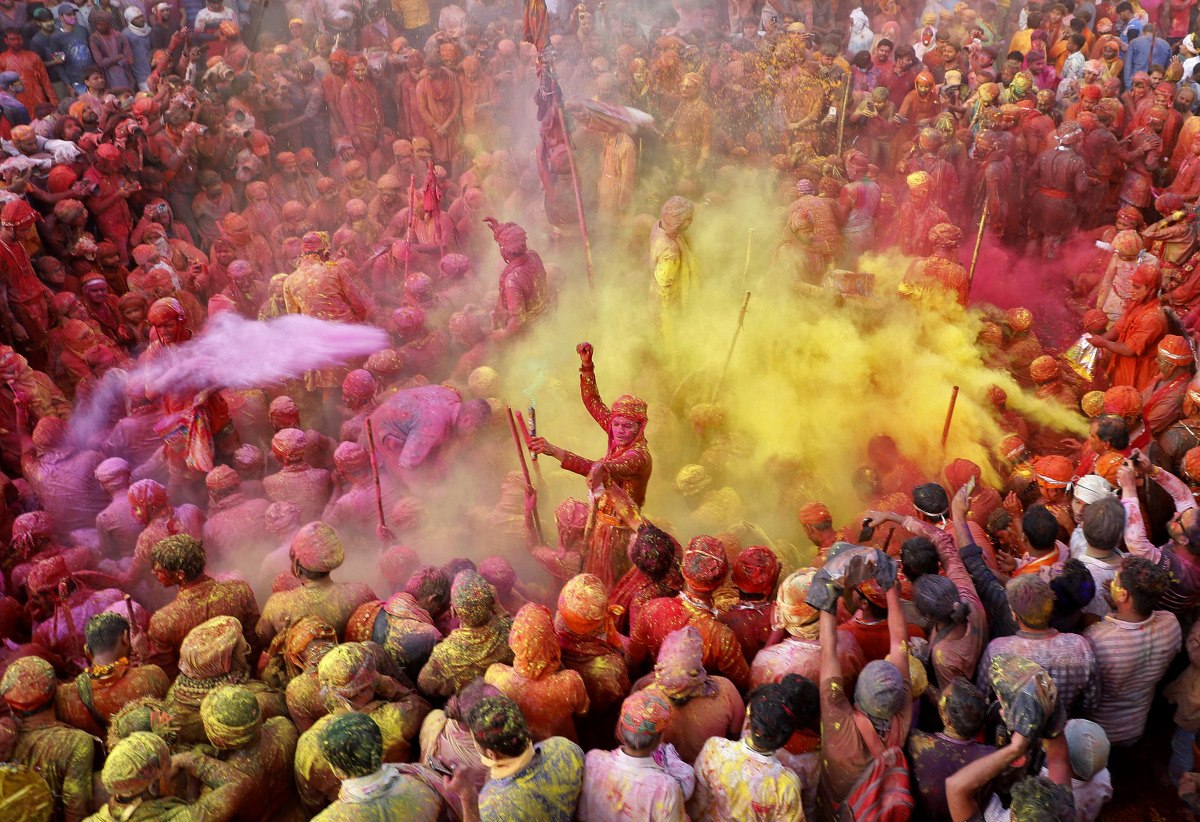 Men daubed in colours throw coloured powder at each other during Lathmar Holi celebrations, amidst the spread of the coronavirus disease (COVID-19), in the town of Nandgaon, in the northern state of Uttar Pradesh, India, March 24, 2021. REUTERS/K. K. Aror