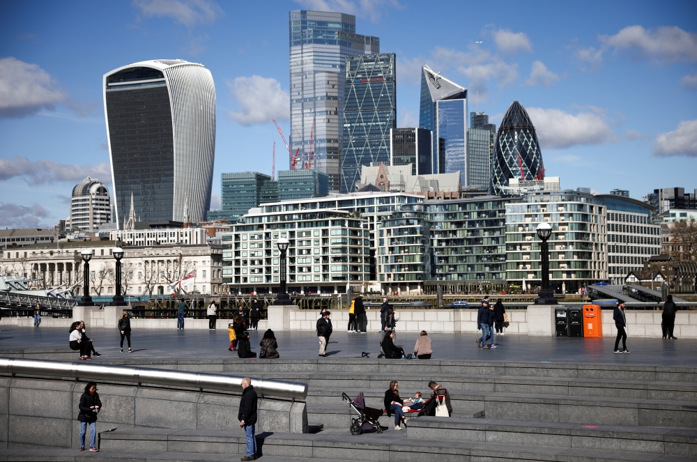 The City of London financial district can be seen as people walk along the south side of the River Thames, amid the coronavirus disease (COVID-19) outbreak in London, Britain, March 19, 2021. REUTERS/Henry Nicholls//File Photo