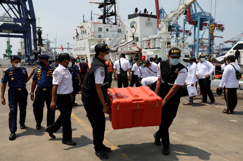 Indonesia's National Transportation Safety Committee (KNKT) officials carry a safety box containing the Cockpit Voice Recorder (CVR) of Sriwijaya Air flight SJ 182, at Tanjung Priok Port in Jakarta, Indonesia, March 31, 2021. REUTERS/Willy Kurniawan