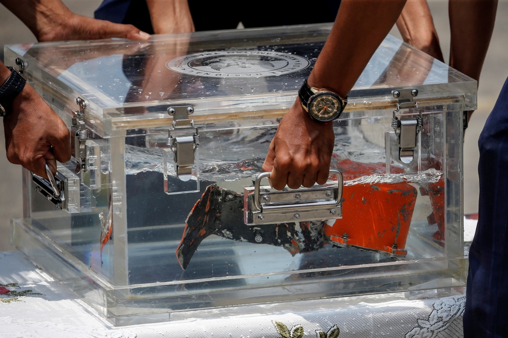 National Transportation Safety Committee (KNKT) officials place the Cockpit Voice Recorder (CVR) of Sriwijaya Air flight SJ 182 on a table at Tanjung Priok Port in Jakarta, Indonesia, March 31, 2021. Reuters/Willy Kurniawan