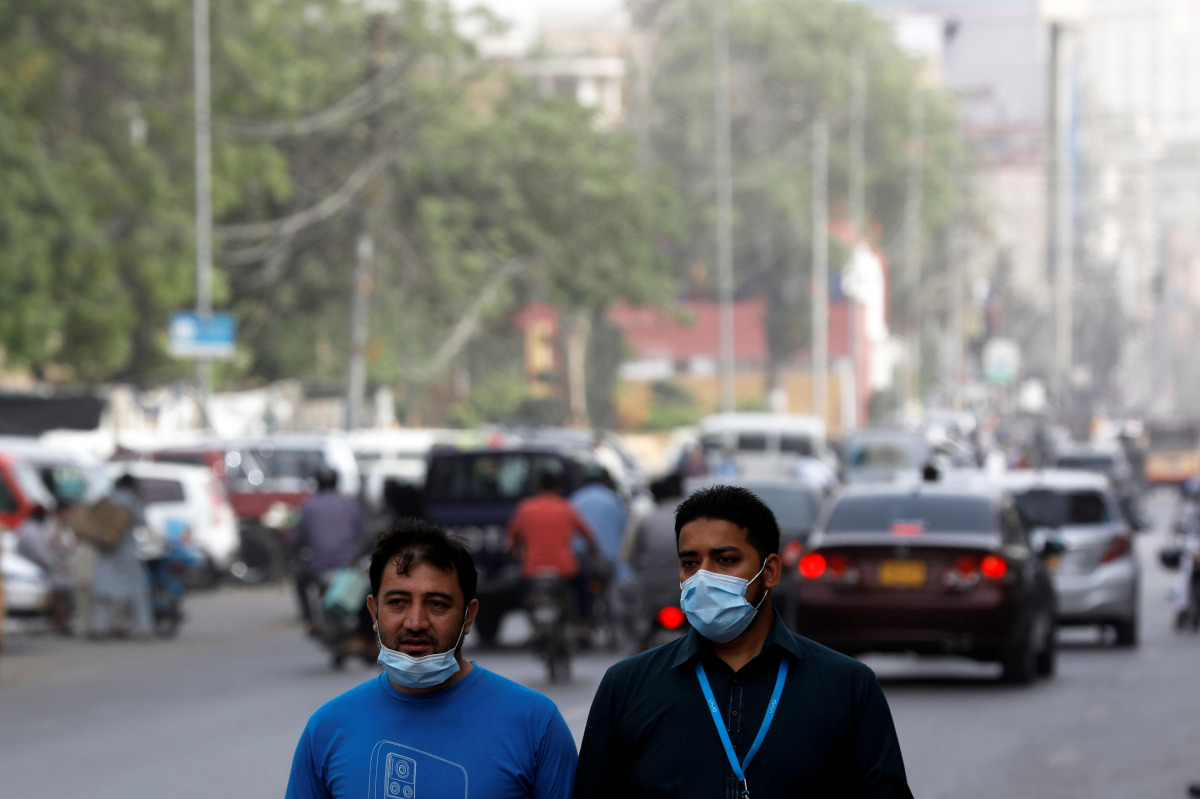 Men wear protective masks as they walk along a road, amid the outbreak of coronavirus disease (COVID-19) in Karachi, Pakistan March 30, 2021. REUTERS/Akhtar Soomro
