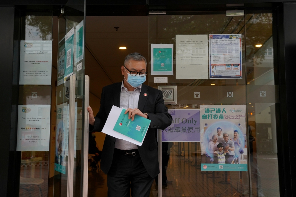 A man wearing a face mask leaves a vaccination centre administering COVID-19 vaccine, in Hong Kong, China March 23, 2021. REUTERS/Lam Yik/File Photo