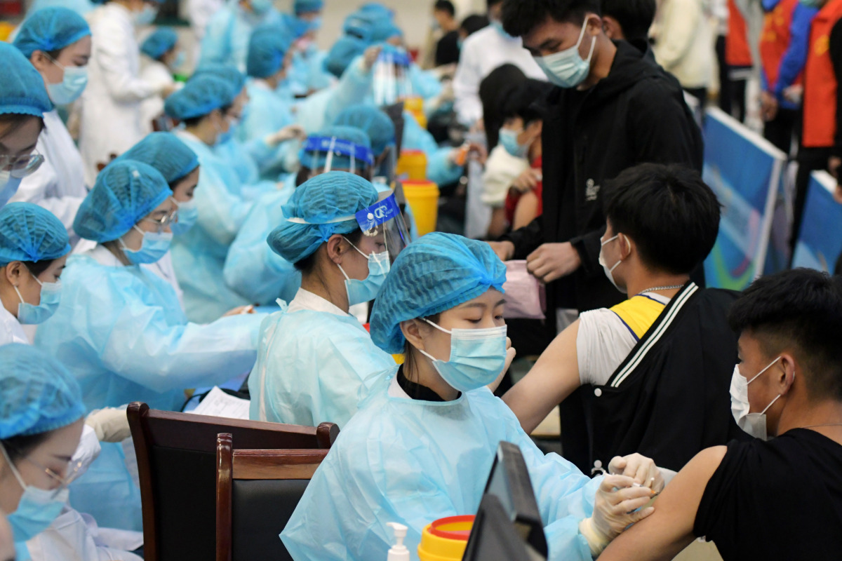 Medical workers inoculate students with the vaccine against the coronavirus disease (COVID-19) at a university in Qingdao, Shandong province, China March 30, 2021. Picture taken March 30, 2021. China Daily via REUTERS 