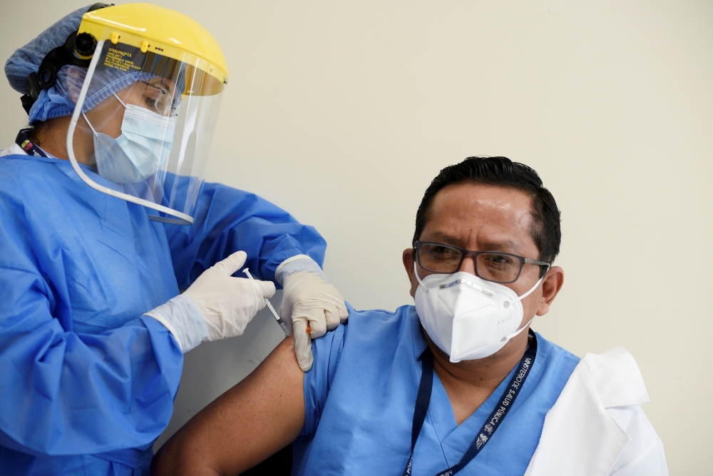 A healthcare worker receives a dose of the Pfizer-BioNTech coronavirus disease (COVID-19) vaccine at the Guasmo Hospital in Guayaquil, Ecuador, January 21, 2021. REUTERS/Santiago Arcos/File Photo