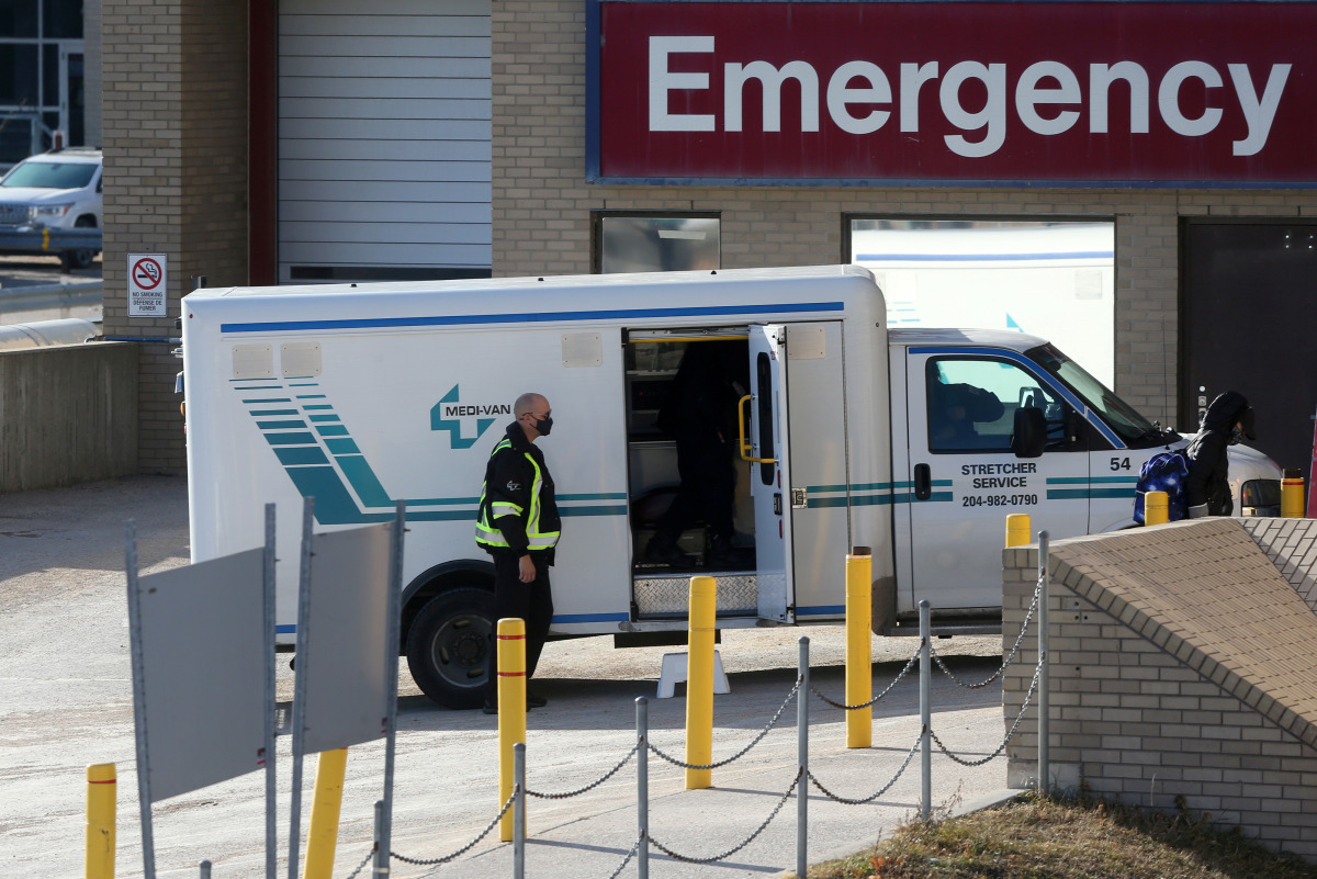 FILE PHOTO: A health care worker in a surgical mask helps unload a stretcher service vehicle at St. Boniface Hospital, which is a reported site of the coronavirus disease (COVID-19) outbreak according to local media, in Winnipeg, Manitoba, Canada, Novembe