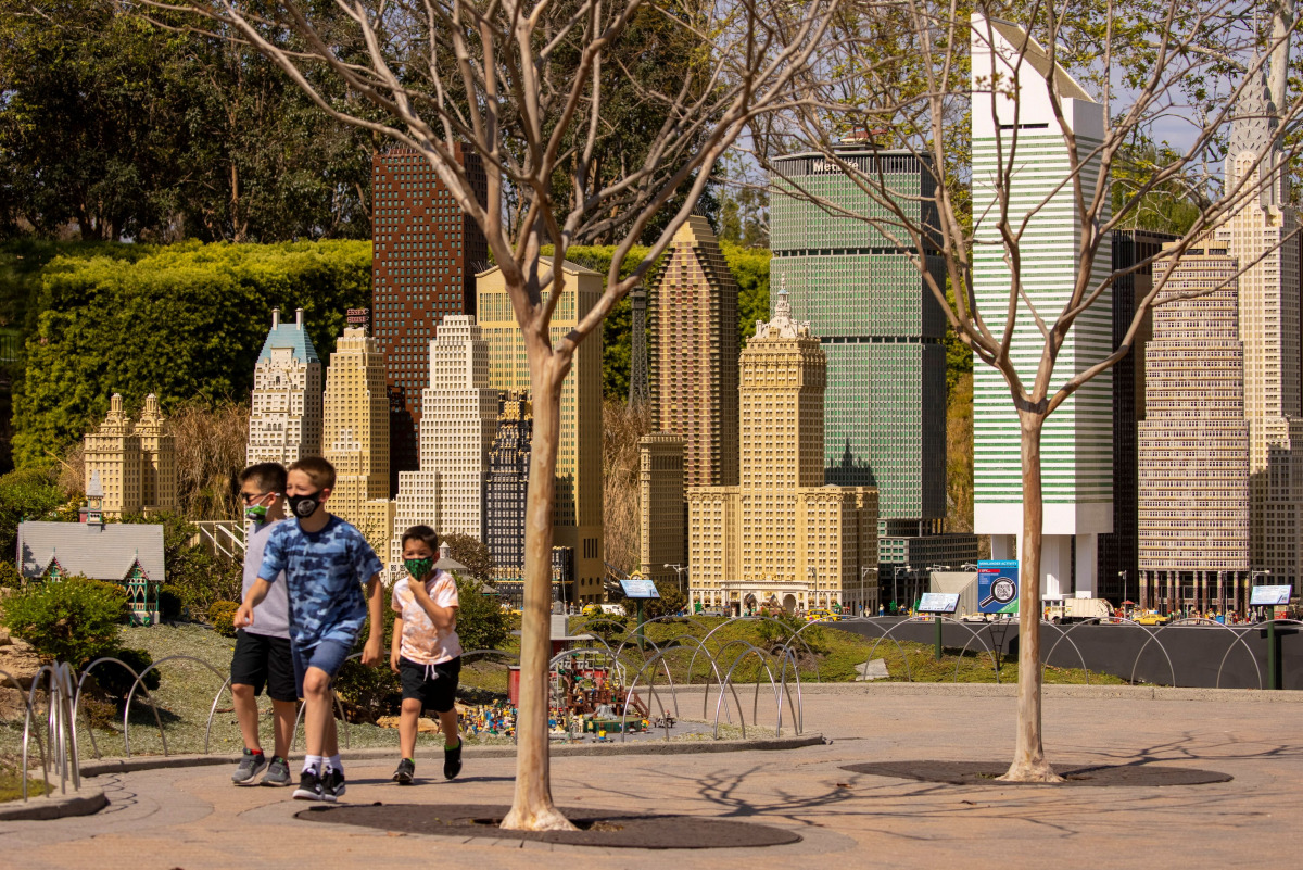 Boys run past a Lego version of New York City as Legoland California reopens for preview days prior to a full opening in Carlsbad, California, U.S., April 1, 2021. REUTERS/Mike Blake
