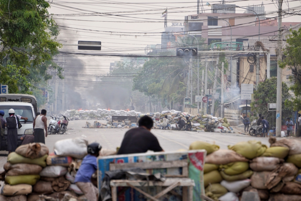 File photo: Protesters take cover behind barricades during a demonstration against the military coup in Mandalay, Myanmar March 21, 2021. Reuters/Stringer/File Photo