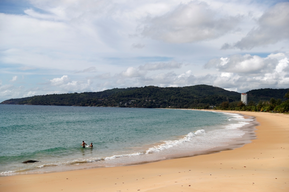 People are seen at an empty beach in Phuket, Thailand, March 31, 2021. Picture taken March 31, 2021. REUTERS/Jorge Silva