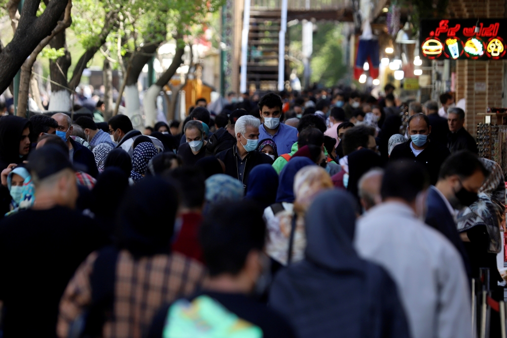 FILE PHOTO: Iranians wearing protective face masks against the coronavirus walk in a crowded area of the capital Tehran, Iran, March 30, 2021. Majid Asgaripour/WANA (West Asia News Agency) via REUTERS/
