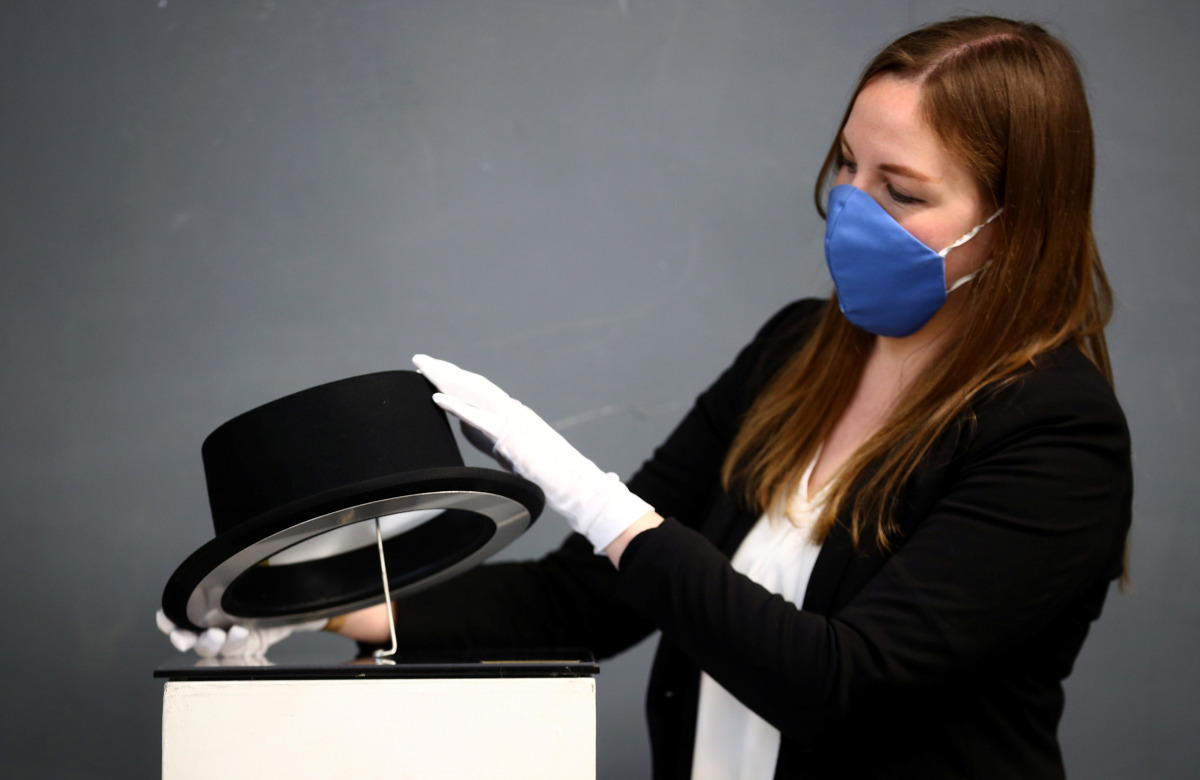 An auctioneer specialist looks at a James Bond replica Top Hat as worn by Oddjob in 'Goldfinger' (estimate £2,000-£4,000) at Ewbank's Auctioneers, ahead of an upcoming sale, in Woking, Britain, April 7, 2021. REUTERS/Hannah McKay
