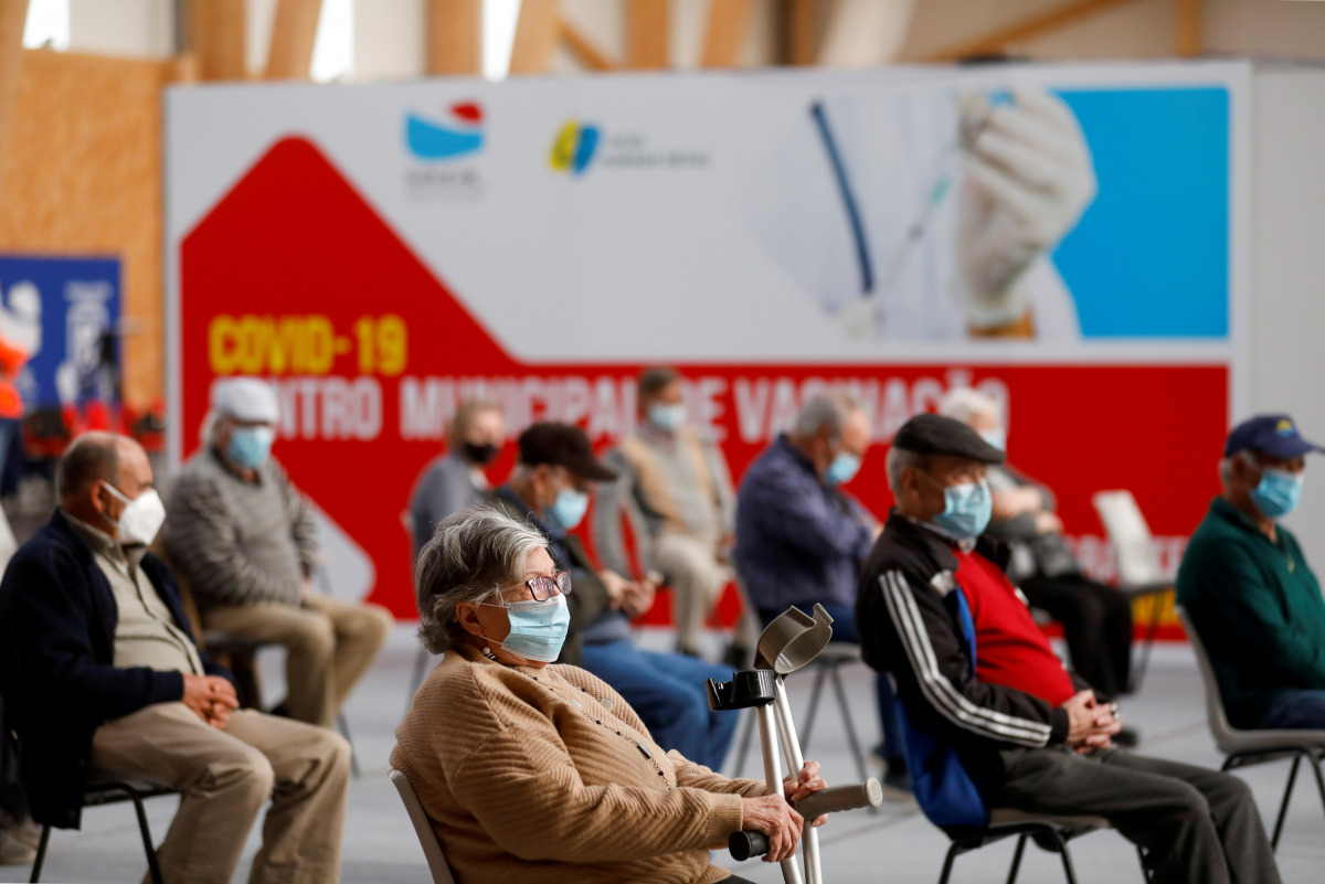 FILE PHOTO: People wait in a COVID-19 vaccination centre, as Portugal resumes vaccination with AstraZeneca shots after a temporary suspension, amid the coronavirus disease (COVID-19) pandemic, in Seixal, Portugal, March 22, 2021. REUTERS/Pedro Nunes/File 