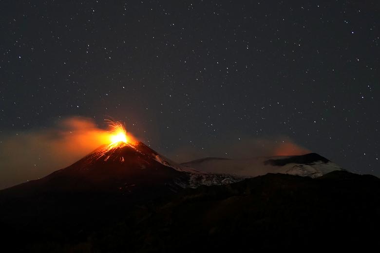 FILE PHOTO: Large streams of red hot lava shoot into the night sky as Mount Etna seen from the village of Fornazzo, Italy, February 3. REUTERS/Antonio Parrinello

