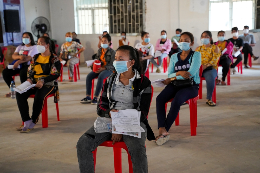 Garment factory workers and staff wait to receive China's Sinovac coronavirus disease (COVID-19) vaccine at an industrial park in Phnom Penh, Cambodia, April 7, 2021. REUTERS/Cindy Liu/File Photo