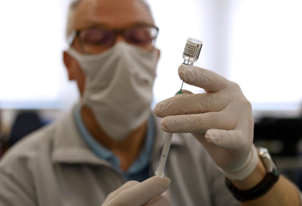 A doctor prepares a dose of the Pfizer-BioNTech coronavirus disease (COVID-19) vaccine in the eastern German town of Weisswasser, Germany, April 9, 2021. REUTERS/Michaela Rehle
