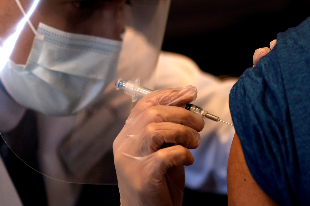 A person receives a dose of the Johnson & Johnson coronavirus disease (COVID-19) vaccine during a visit of U.S. Vice President Kamala Harris to a vaccination center in Chinatown, in Chicago, Illinois, U.S., April 6, 2021. Picture taken April 6, 2021. REUT