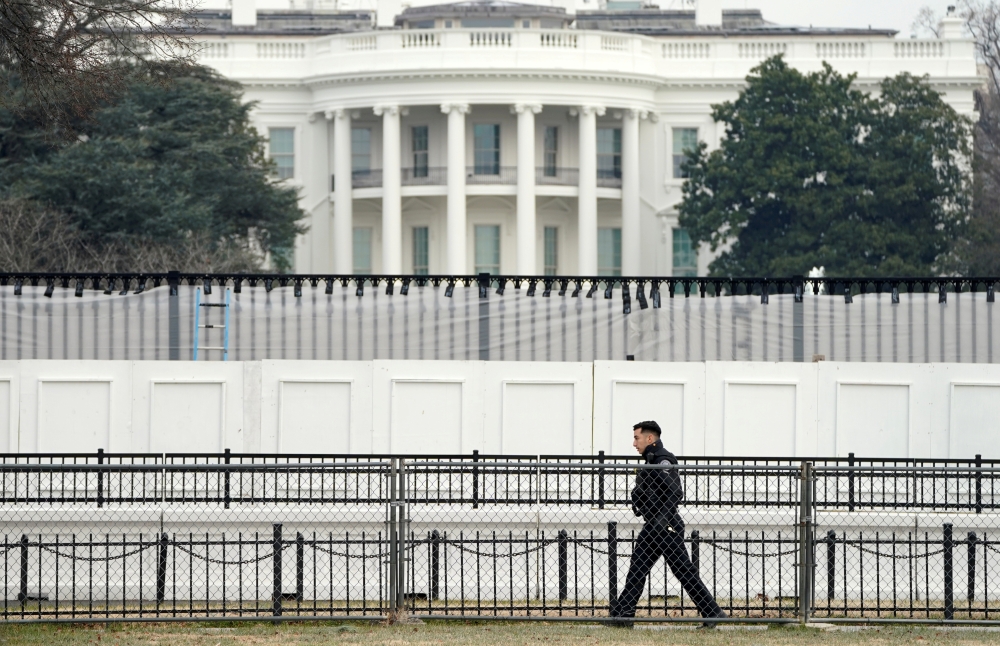 A member of the Secret Service walks along security fence installed around the White House days after supporters of U.S. President Donald Trump stormed the Capitol in Washington, U.S., January 11, 2021. REUTERS/Kevin Lamarque/File Photo