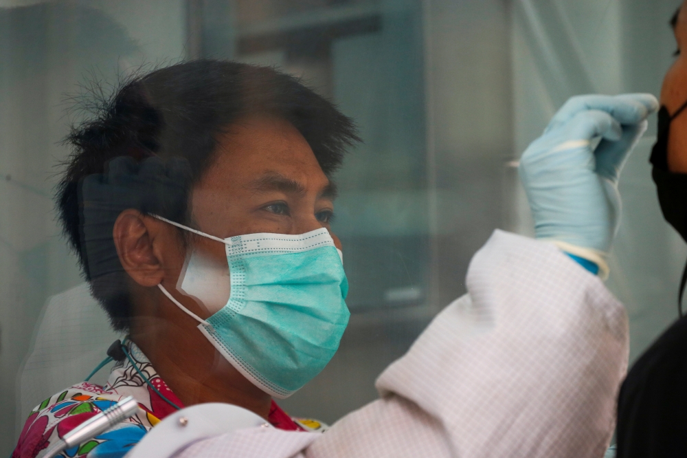 A healthcare worker performs a coronavirus disease (COVID-19) nasal swab test on a local resident, in Bangkok, Thailand, April 14, 2021. Reuters/Soe Zeya Tun