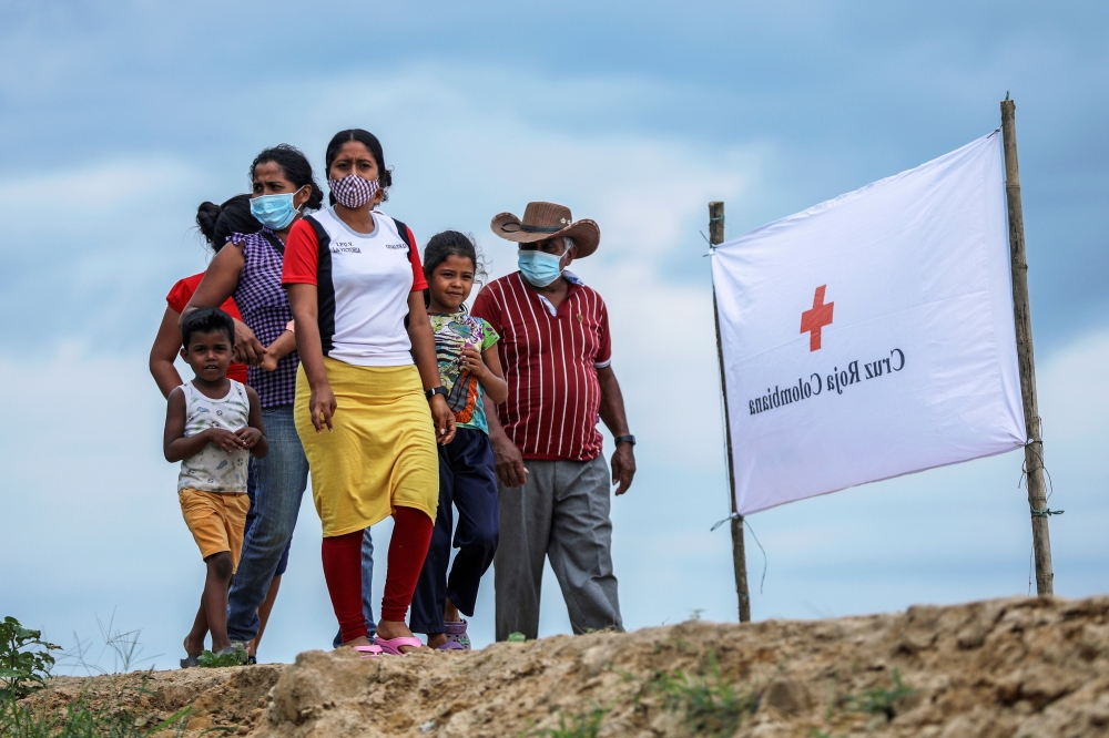 File photo: Venezuelan refugees walk to a school where a temporary shelter has been set up, to receive medical assistance and humanitarian aid from the Colombian Red Cross, in Arauquita, Colombia March 28, 2021. Reuters/Luisa Gonzalez/File Photo