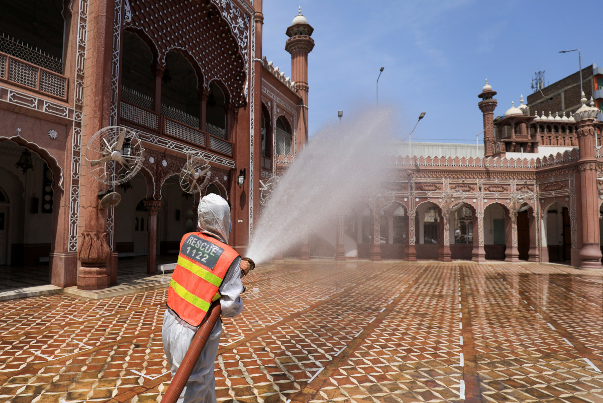 A worker sprays disinfectant to sanitize a mosque ahead of the holy fasting month of Ramadan, as the spread of coronavirus disease (COVID-19) continues, in Peshawar, Pakistan April 13, 2021. REUTERS/Fayaz Aziz 