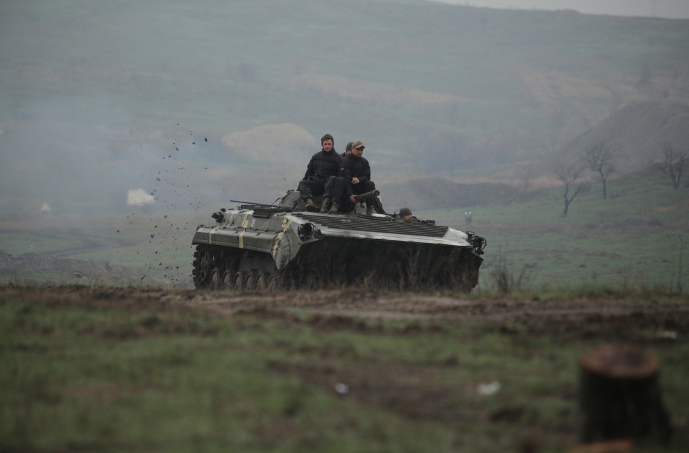 Service members of the Ukrainian armed forces drive an armoured vehicle during a training at a firing range in Donetsk region, Ukraine April 20, 2021. REUTERS/Serhiy Takhmazov