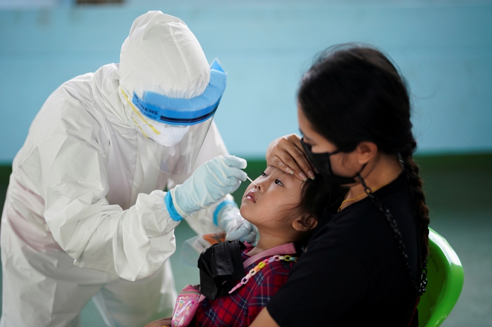 A healthcare worker takes a nasal swab sample from a child for a coronavirus disease (COVID-19) test, as the country deals with a fresh wave of infections after tackling earlier outbreaks, in Bangkok, Thailand April 16, 2021. REUTERS/Athit Perawongmetha/F