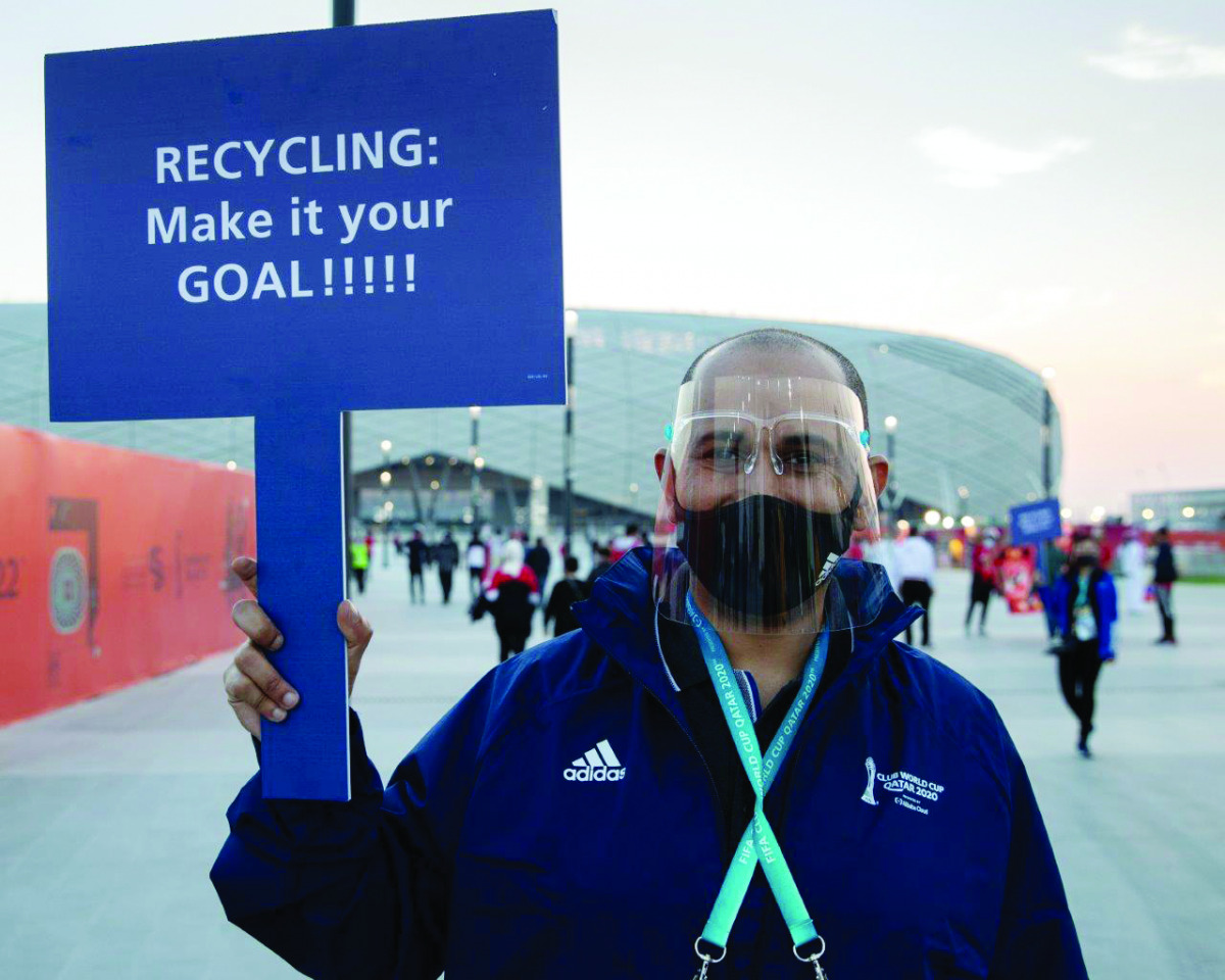 A man is waving a banner to promote recycling.