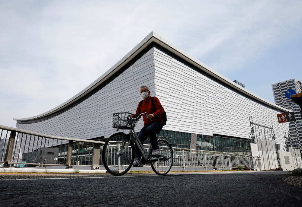 File photo: A man wearing a protective mask amid the coronavirus disease (COVID-19) outbreak cycles past Ariake Arena in Tokyo, Japan, April 8, 2021. Reuters/Kim Kyung-Hoon/File Photo