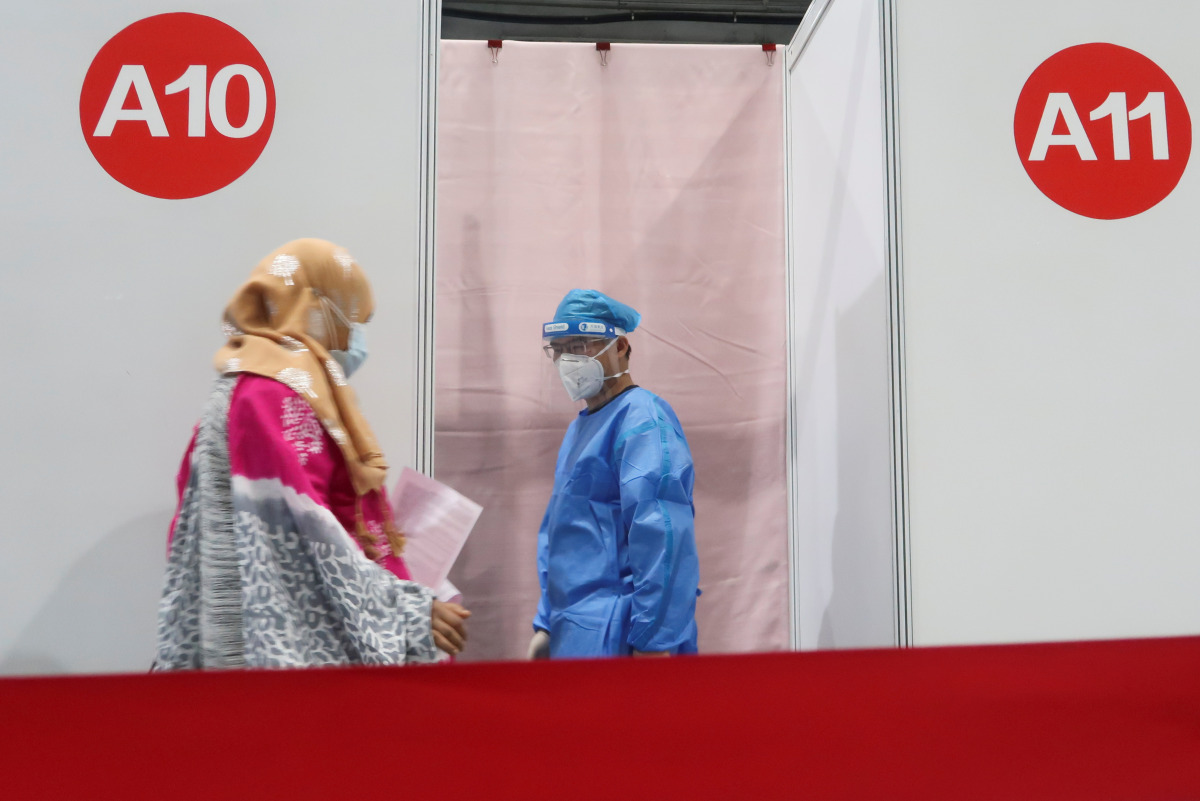 A woman enters a booth to get a coronavirus disease (COVID-19) vaccine at a vaccination center, during a government-organized visit, in Beijing, China, April 15, 2021. REUTERS/Thomas Peter
