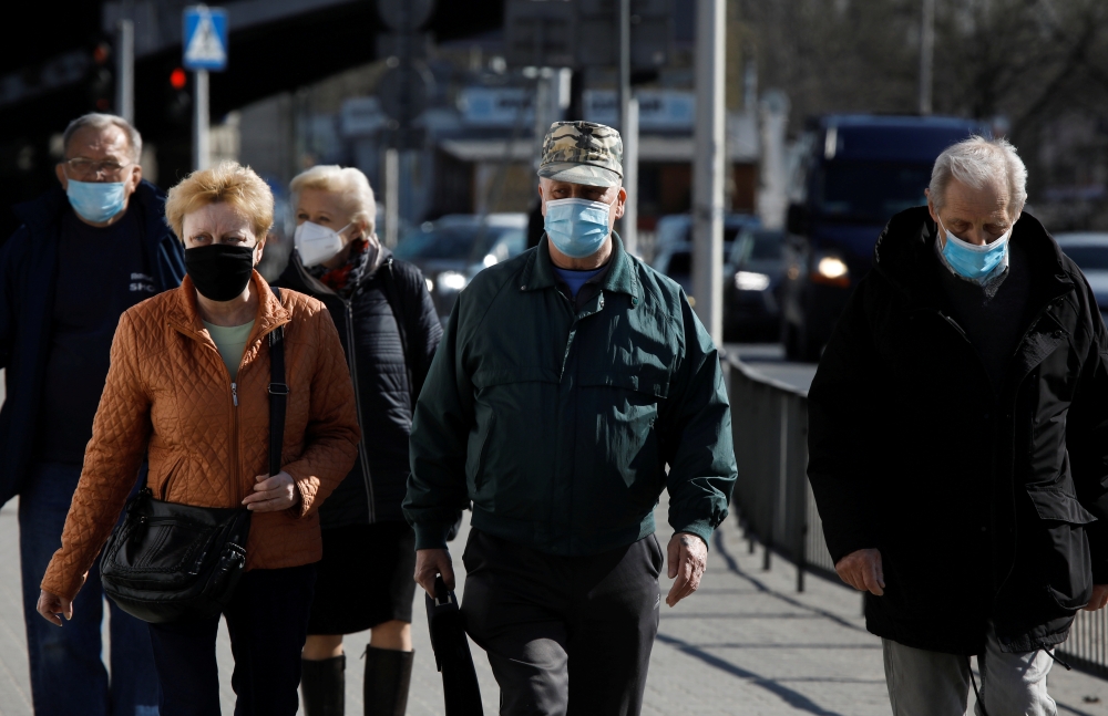 People wearing protective masks walk in Warsaw, Poland, April 2, 2021. REUTERS/Kacper Pempel/File Photo