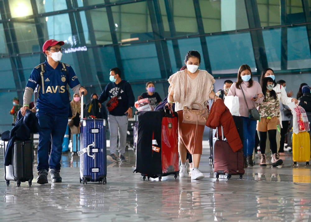 Visitors walk after they arrived at the Soekarno-Hatta Airport following Indonesia's government decision to ban foreign tourists from entry to prevent the spread of coronavirus disease (COVID-19), in Tangerang, on the outskirts of Jakarta, Indonesia, Janu