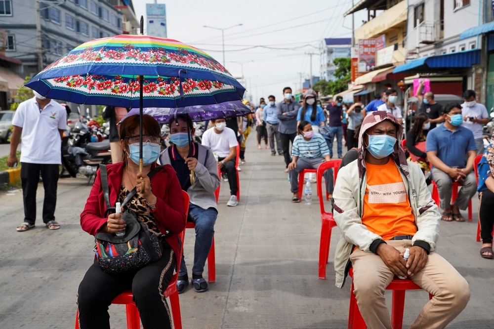 People wait in line before being vaccinated against coronavirus disease (COVID-19) in Phnom Penh, Cambodia, April 22, 2021. REUTERS/Cindy Liu