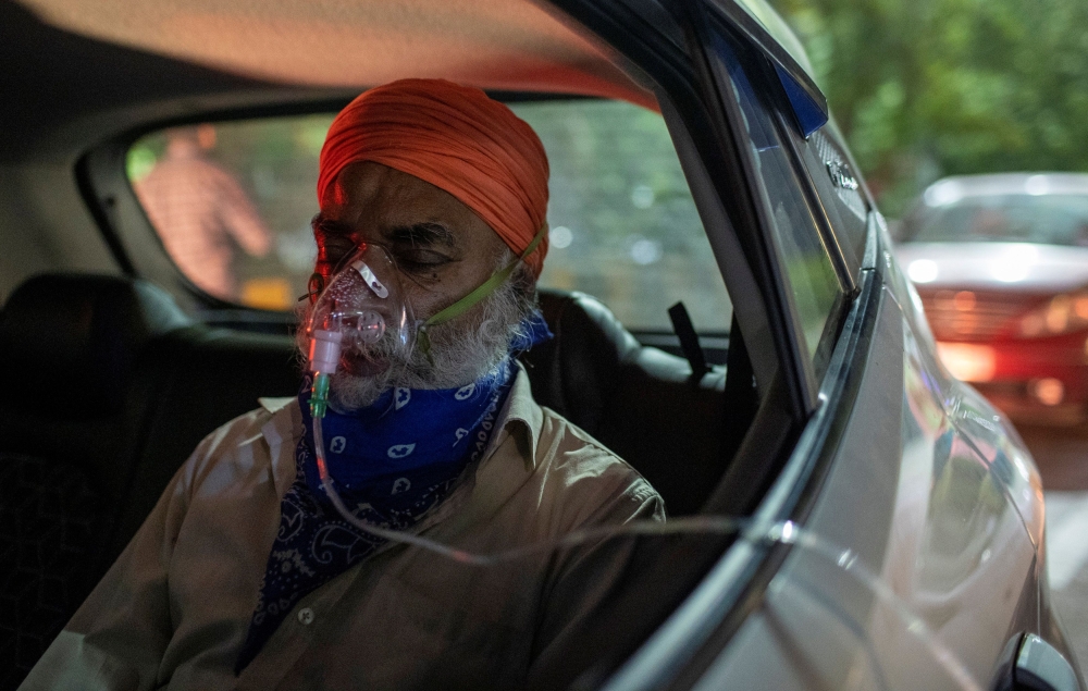 A man with a breathing problem receives oxygen support for free inside his car at a Gurudwara (Sikh temple), amidst the spread of coronavirus disease (COVID-19), in Ghaziabad, India, April 24, 2021. Picture taken April 24, 2021. REUTERS/Danish Siddiqui