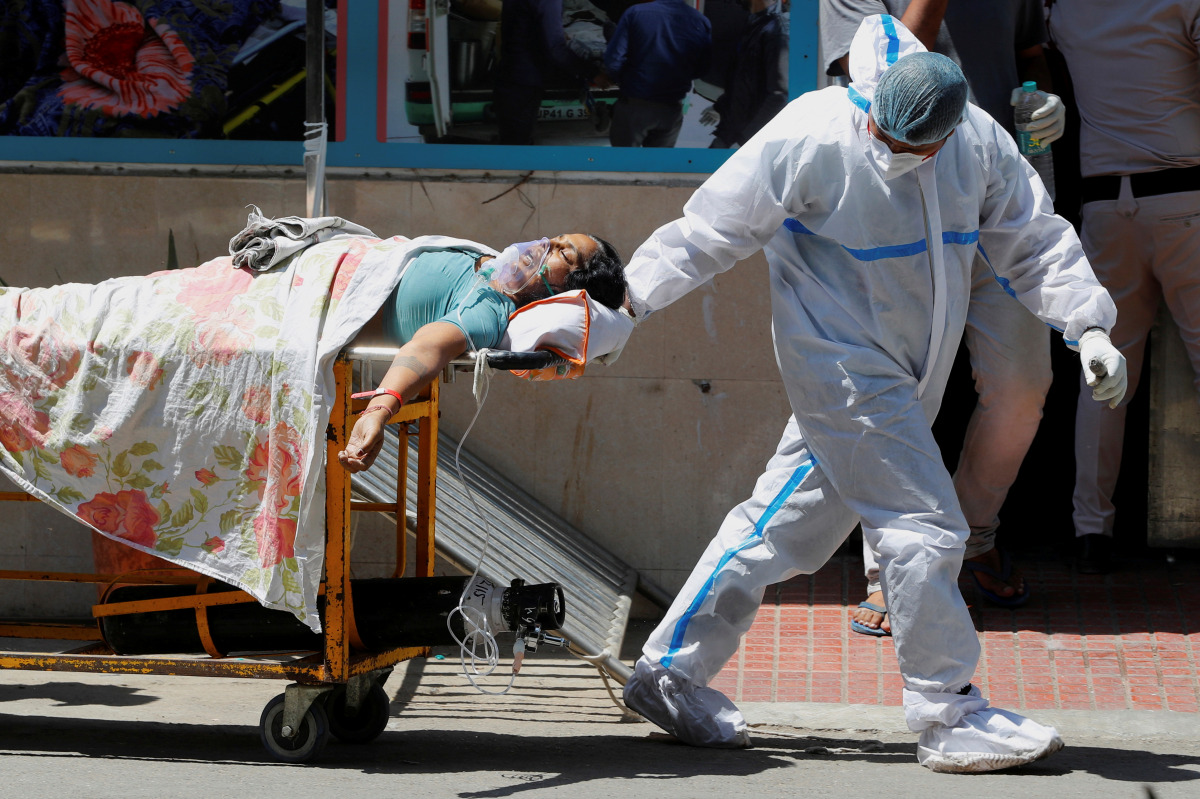 A health worker wearing personal protective equipment (PPE) carries a patient suffering from the coronavirus disease (COVID-19) outside the casualty ward at Guru Teg Bahadur hospital, in New Delhi, India, April 24, 2021. REUTERS/Adnan Abidi TPX IMAGES OF 