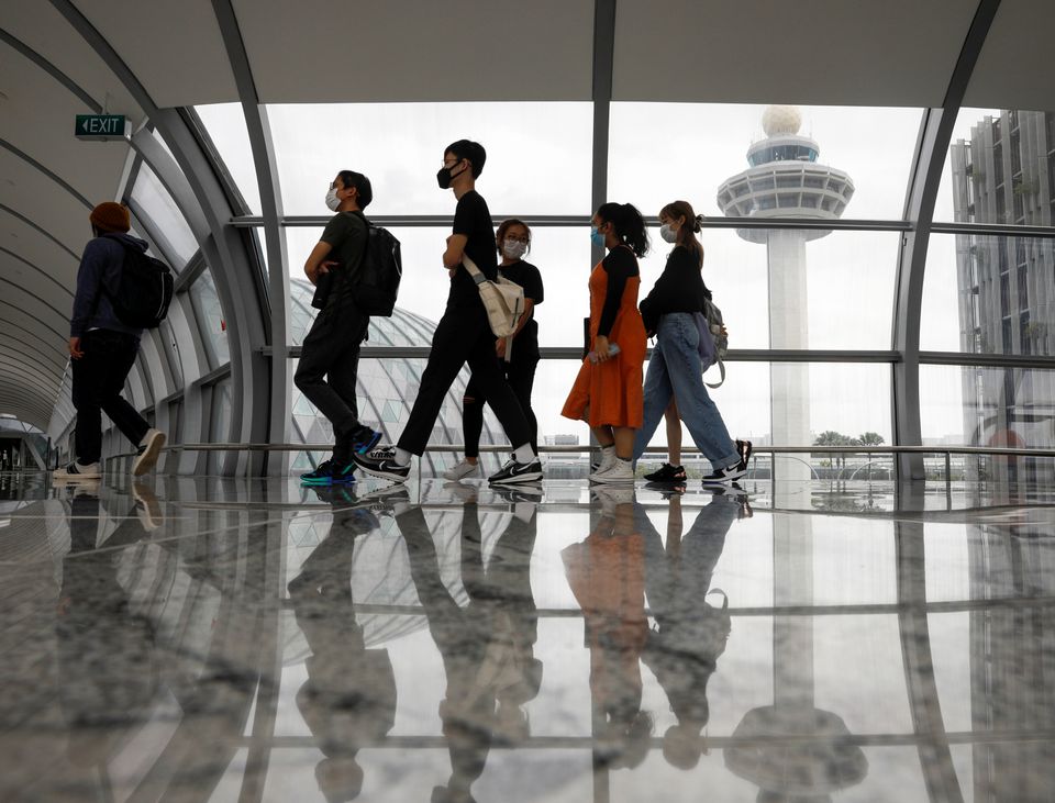 People pass the control tower of Singapore's Changi Airport, Singapore January 18, 2021. REUTERS/Edgar Su


