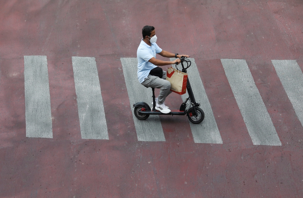 A man wearing a face mask rides a scooter amid the coronavirus disease (COVID-19) outbreak, in Bangkok, Thailand, April 23, 2021. REUTERS/Soe Zeya