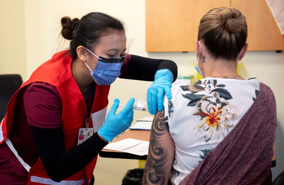 Nurse Venus Lucero administers the first Pfizer-BioNTech COVID-19 vaccine at the Civic Hospital to Jo-Anne Miner at a vaccination clinic in Ottawa, Ontario, Canada December 15, 2020. Adrian Wyld/Pool via REUTERS