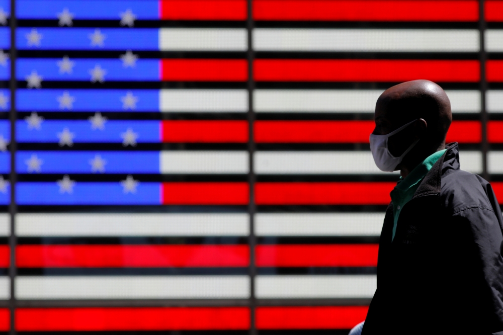 A person walks in Times Square after the Centers for Disease Control and Prevention (CDC) announced new guidelines regarding outdoor mask wearing and vaccination during the outbreak of the coronavirus disease (COVID-19) in Manhattan, New York City, New Yo