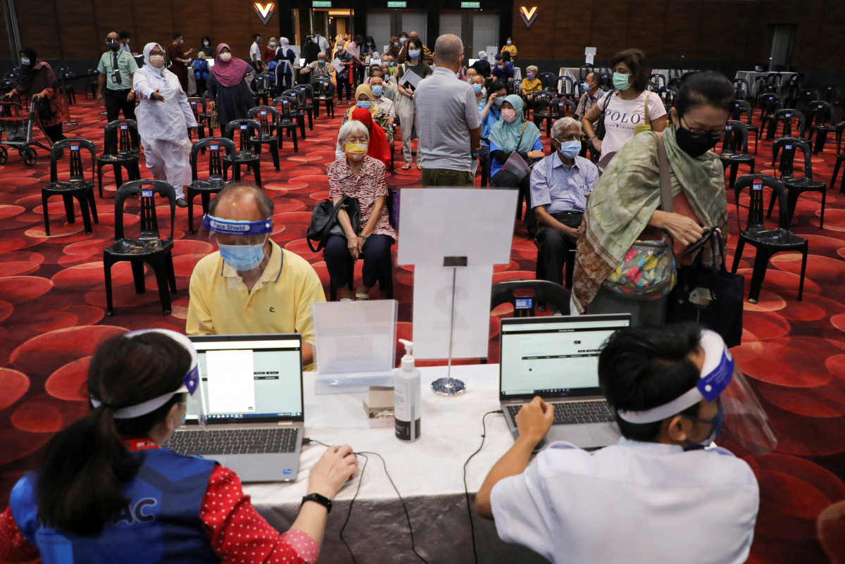 People wait to receive a vaccine for the coronavirus disease (COVID-19) at a vaccination centre in Subang Jaya, Malaysia April 26, 2021. REUTERS/Lim Huey Teng
