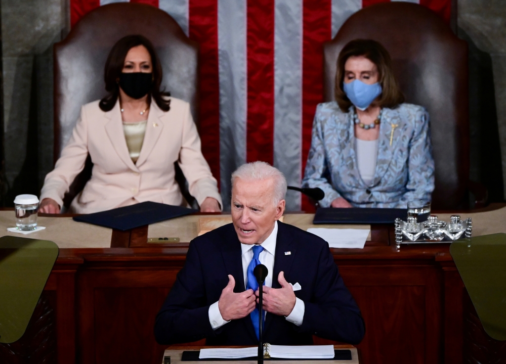 US Vice president Kamala Harris and Speaker of the House Nancy Pelosi listen as U.S. President Joe Biden addresses a joint session of Congress in the House chamber of the US Capitol in Washington, U.S., April 28, 2021. Doug Mills/Pool via Reuters