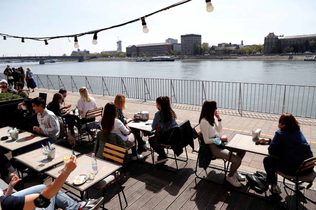 Guests enjoy the sunny weather as they sit in front of a restaurant after the Hungarian government allowed to reopen outdoor terraces, as the spread of the coronavirus disease (COVID-19) continues in Budapest, Hungary, April 24, 2021. REUTERS/Bernadett Sz