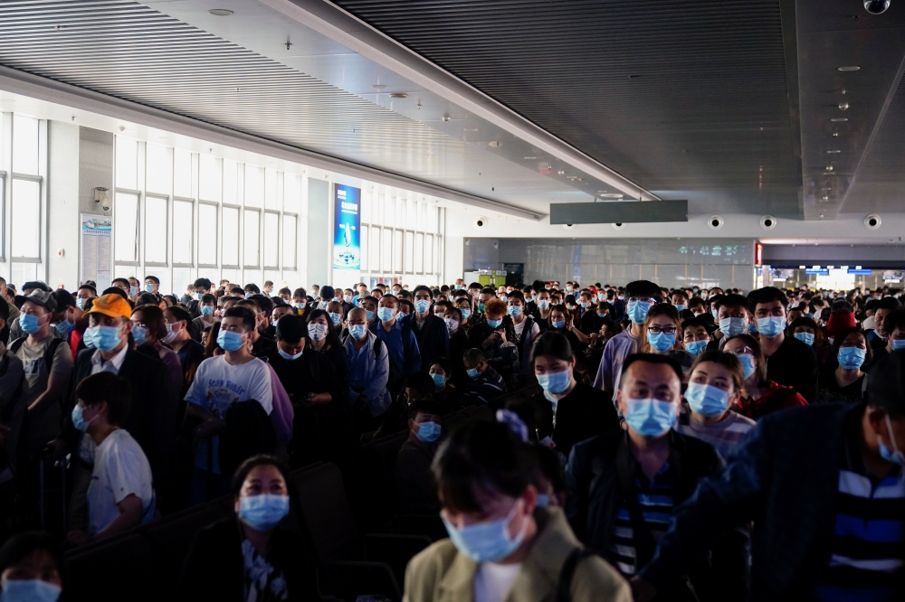 People wearing masks are seen arriving at Shanghai railway station in Shanghai, ahead of the 5-day Labor Day holidays, in China April 30, 2021. REUTERS/Aly Song