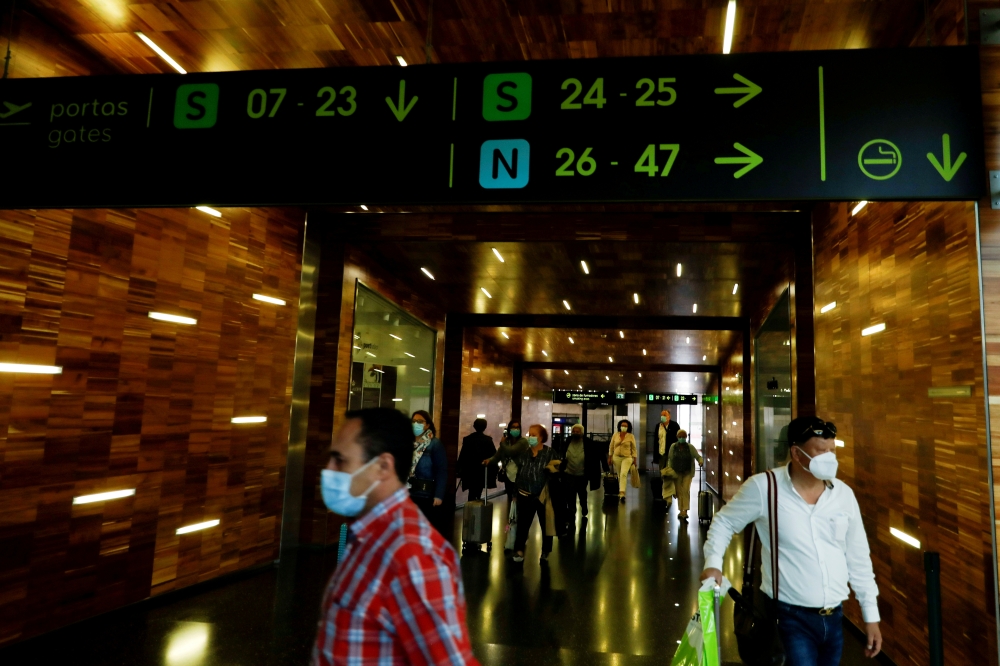 Passengers wearing protective face masks walk at Lisbon's airport during the coronavirus disease (COVID-19) outbreak, in Lisbon, Portugal June 15, 2020. Reuters/Rafael Marchante/File Photo