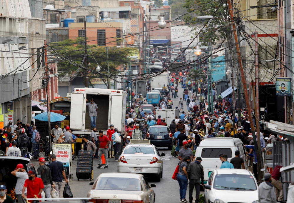 People walk on a busy commercial street amid a spike in infections of the coronavirus disease (COVID-19) that has led the government to extend lockdown measures, in Caracas, Venezuela April 6, 2021. REUTERS/Leonardo Fernandez Viloria/File Photo/File Photo