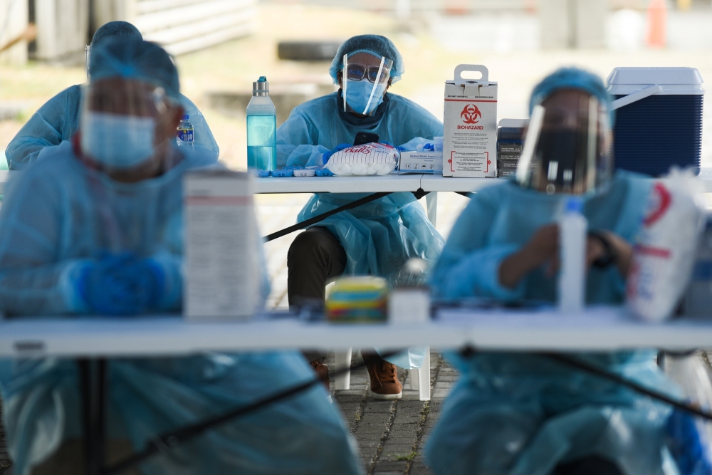 Health workers wait for the arrival of residents to be vaccinated against the coronavirus disease (COVID-19) at a drive-thru vaccination site for bedridden and persons with disabilities, in Makati city, Metro Manila, Philippines, May 7, 2021. REUTERS/Lisa
