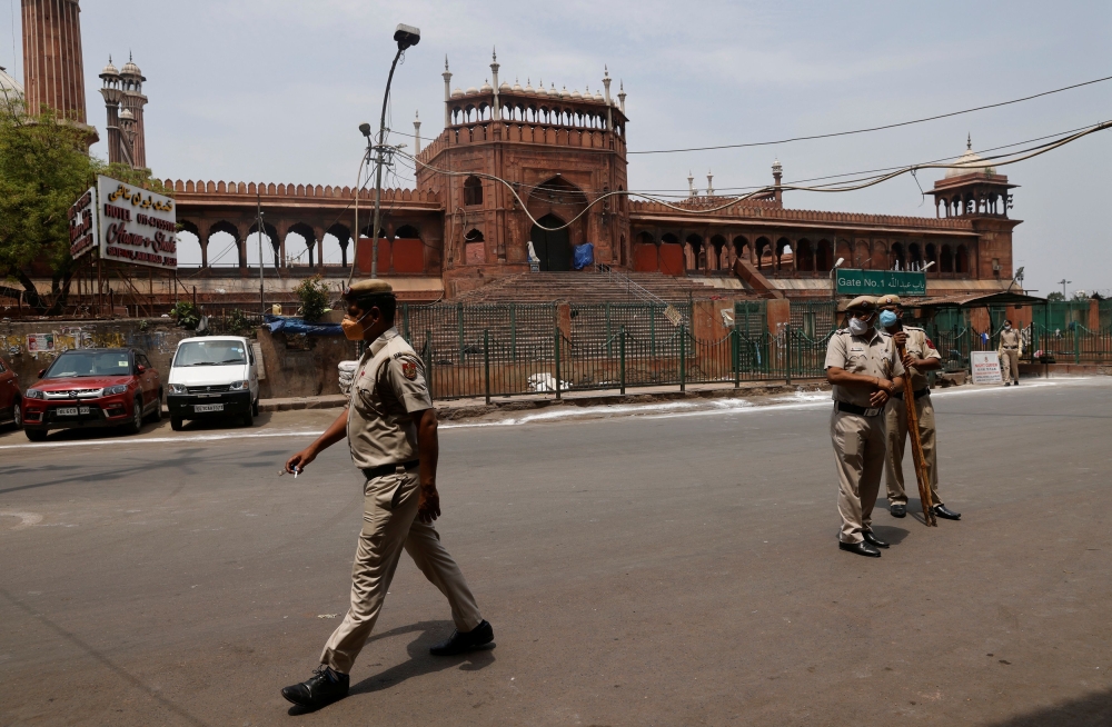 Policemen stand in front of Jama Masjid or Grand Mosque on Jumat-ul-Vida or the last Friday of the holy fasting month of Ramadan, during a lockdown to limit the spread of the coronavirus disease (COVID-19), in the old quarters of Delhi, India, May 7, 2021