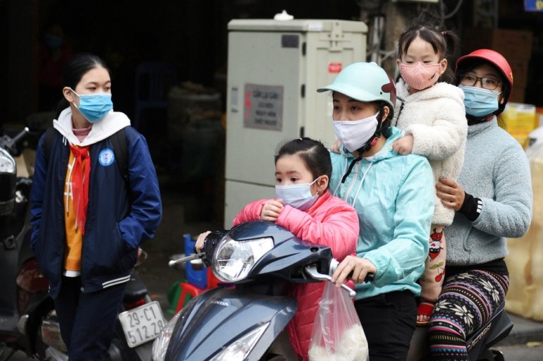 A family wears protective masks as they ride a motorbike in the street amid the coronavirus disease (COVID-19) outbreak in Hanoi, Vietnam, January 29, 2021. REUTERS/Thanh Hue/File Photo

