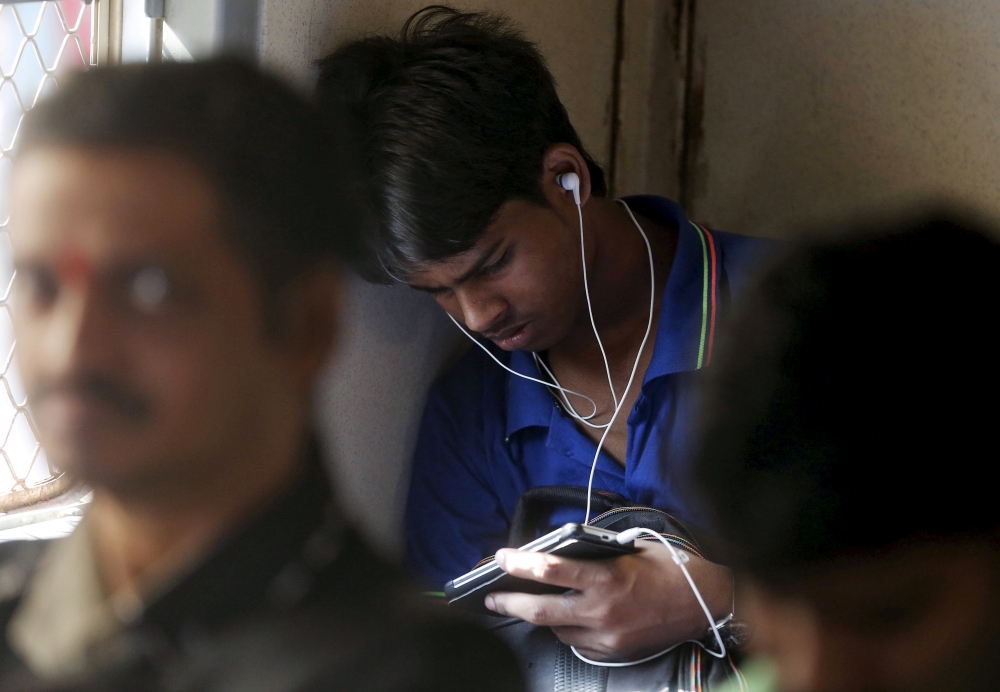 File photo: A man watches a video on his mobile phone as he commutes by a suburban train in Mumbai, India. Reuters/Shailesh Andrade/File Photo